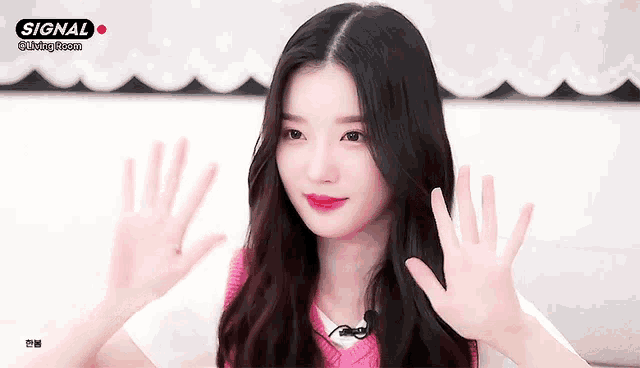 a girl is waving her hands in front of a sign that says signal on it