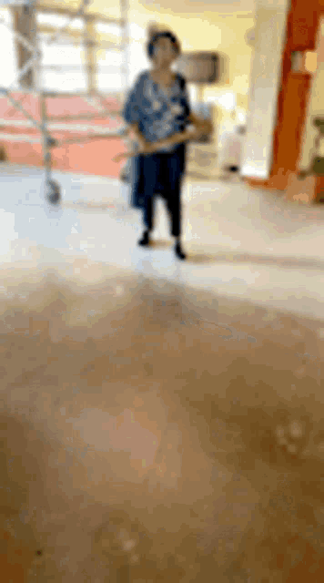 a woman is standing on a dirty floor in a room .