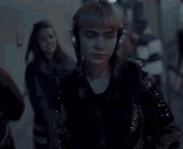 a woman is wearing headphones and singing into a microphone