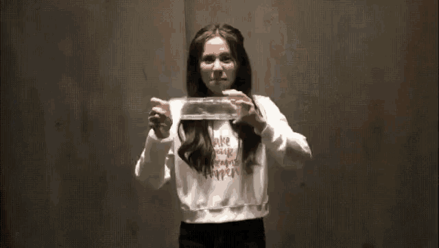 a woman is dancing in a room with her hands in the air .