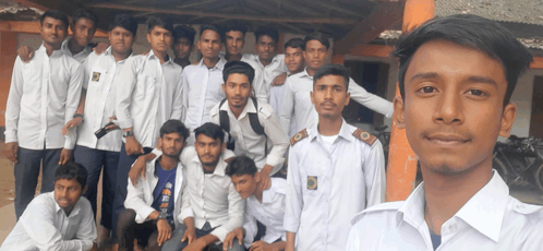 a group of young men posing for a picture with one wearing a blue shirt that says ' eee ' on it