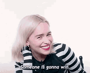 a woman in a black and white striped shirt is smiling and saying `` someone is gonna win '' .