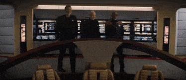 three men are standing in front of a display that says u.n.s.s. on it