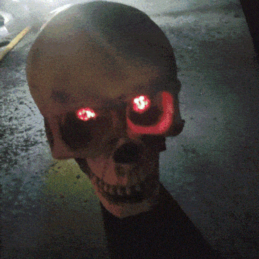 a close up of a skull with red eyes and a dollar sign on it