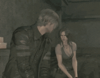 a man in a leather jacket stands next to a woman in a plunging top