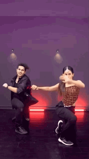a man and a woman are dancing together in a room with red lights