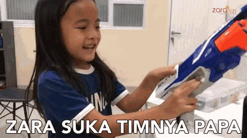 a little girl holding a nerf gun with the words zara suka timnya papa written on the bottom