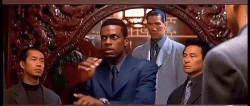 a group of men are standing around a man in a blue suit