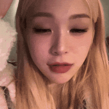 a close up of a blonde woman 's face with red lips