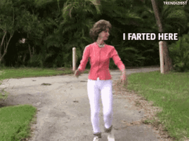 a woman walking down a path with the words i farted here written on the bottom