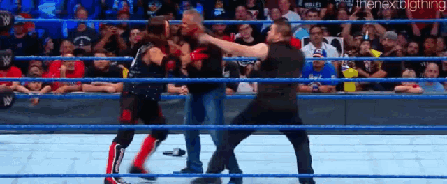 a group of men are fighting in a wrestling ring .