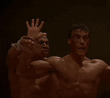 two men are wrestling in a dark room and one of them is carrying the other on his back