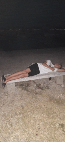 a person laying on a bench with a white shirt that says nike