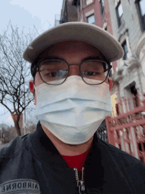 a man wearing glasses and a face mask has the word vibobine on his shirt