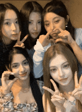 a group of young women are posing for a picture and one of them is wearing a ring on her finger