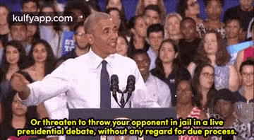 barack obama is giving a speech in front of a crowd while standing in front of a microphone .