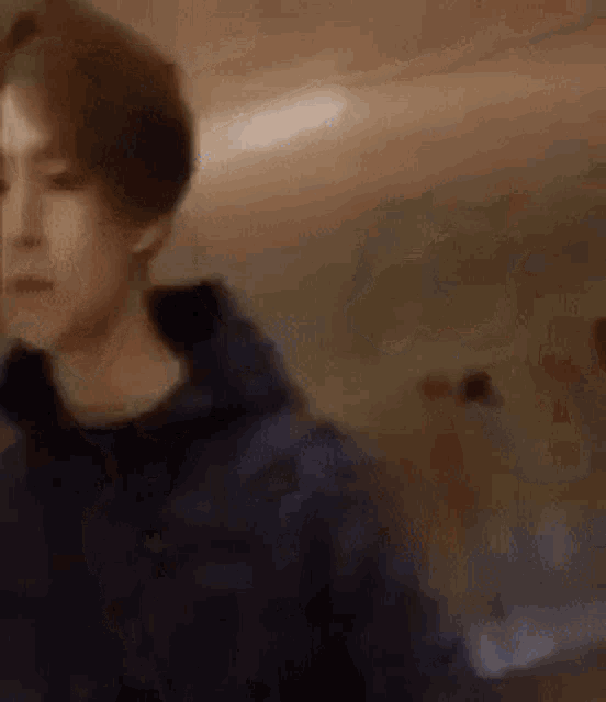 a man in a blue hoodie is standing in a room .