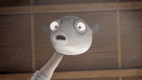 a person is holding a puffer fish with a surprised look on their face