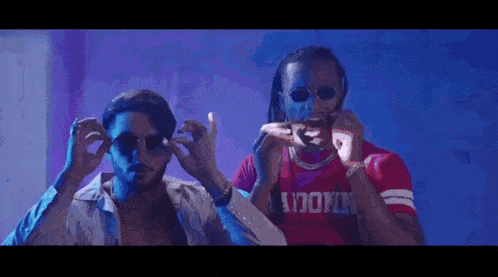 two men wearing sunglasses and a red shirt with the word brooklyn on it .
