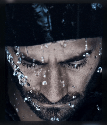 a close up of a man 's face with water coming out of his eyes