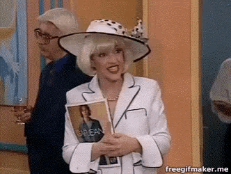 a woman in a white suit and hat is holding a magazine that says caribbean .