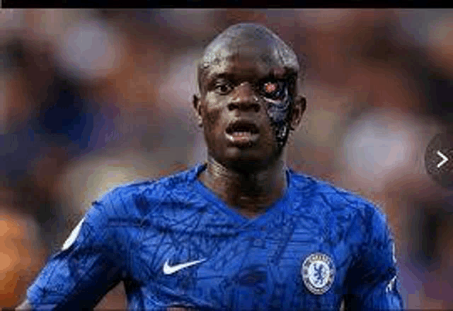 a soccer player with a robotic face is wearing a blue shirt .