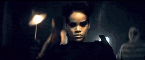 a woman is holding a gun in her hand and making a face .