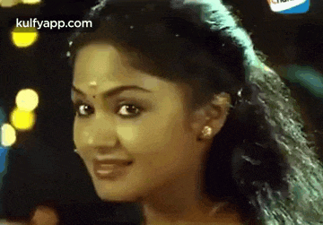 a close up of a woman 's face with a blurred background and the words kulfyapp.com on the bottom .
