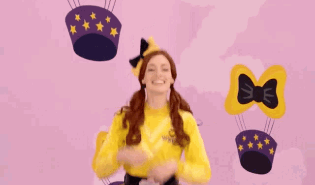 a woman in a yellow outfit with a bow on her head
