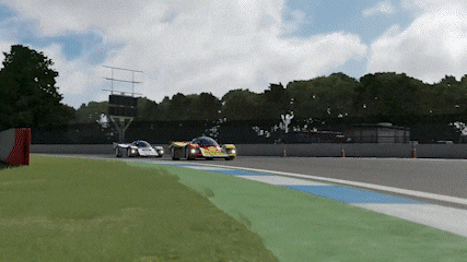 three racing cars are driving down a track with a scoreboard in the background