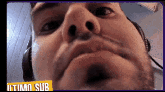 a close up of a man 's face with headphones and a sign that says ultimo sub