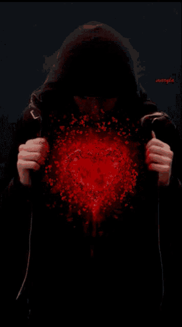 a man in a hooded jacket is holding a red heart in his hands