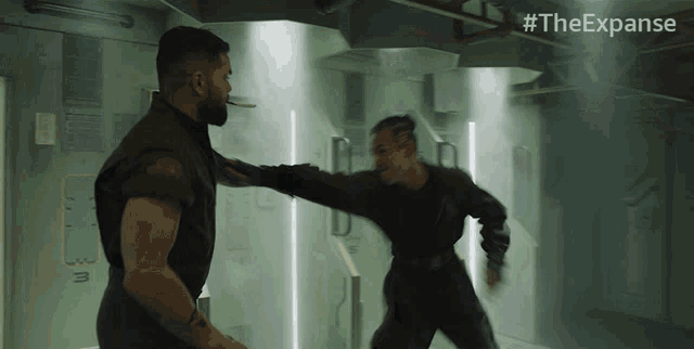 two men are fighting in a room with #theexpanse on the bottom