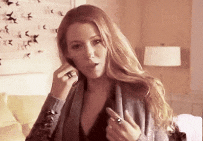 a woman is talking on a cell phone in a living room while wearing a ring on her finger .