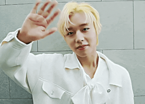 a man with blonde hair is wearing a white shirt and bow tie