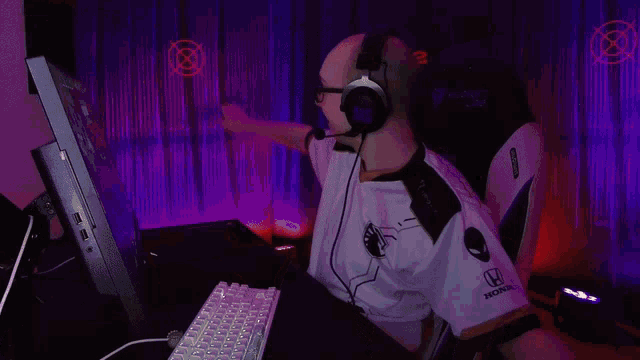 a bald man wearing glasses and headphones is sitting in front of a computer screen with the number 22 on it