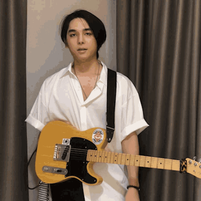 a man in a white shirt is holding a guitar with a sticker on it that says ' california '