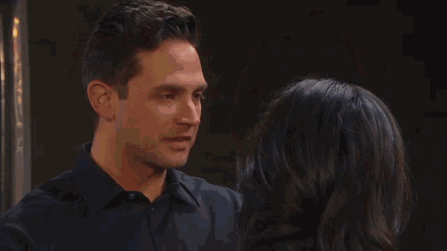 a man and a woman are looking at each other with a serious look on their faces