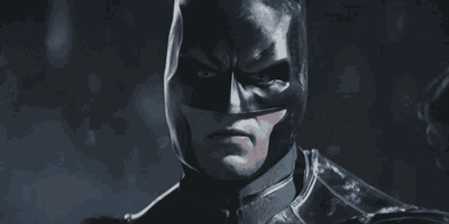 a close up of a man in a batman costume looking at the camera