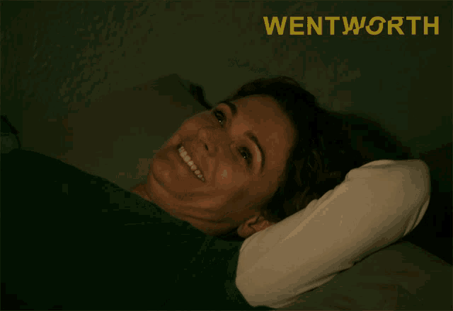 a woman laying on a bed with the word wentworth written above her