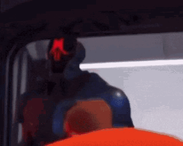 a cartoon character is standing in front of a window with a red light on his head .