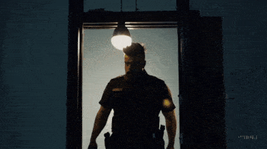 a police officer is standing in a doorway with a sign that says exit