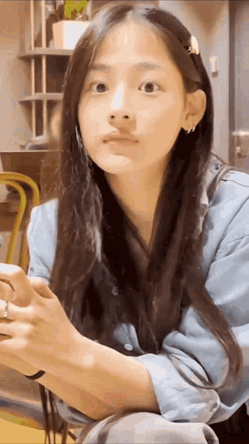 a young girl with long hair is sitting in a chair