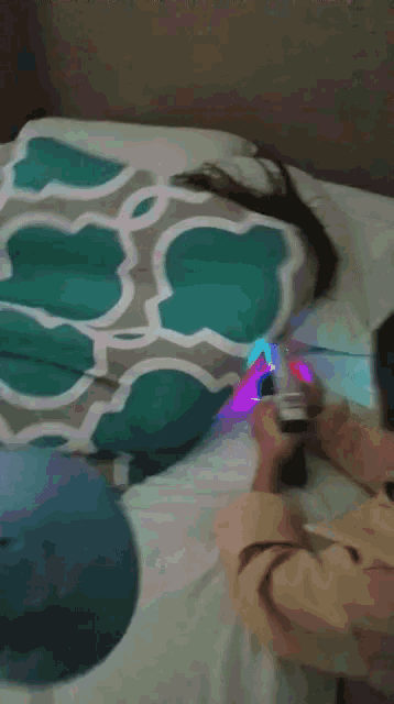 a person laying on a bed with a blue and grey blanket