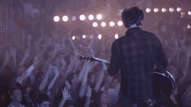 a group of people standing on stage with their hands in the air