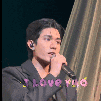 a man singing into a microphone with the words " i love yuo " written in pink