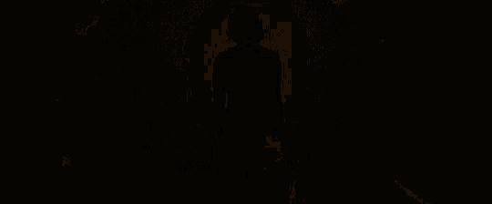 a woman is standing in a dark room in front of a man .