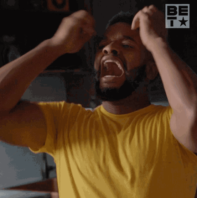 a man in a yellow shirt is screaming in front of a sign that says be