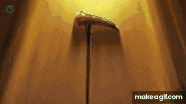 a cane with a scythe on it is standing in front of a light .