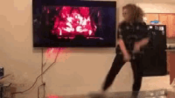 a woman is dancing in front of a flat screen tv